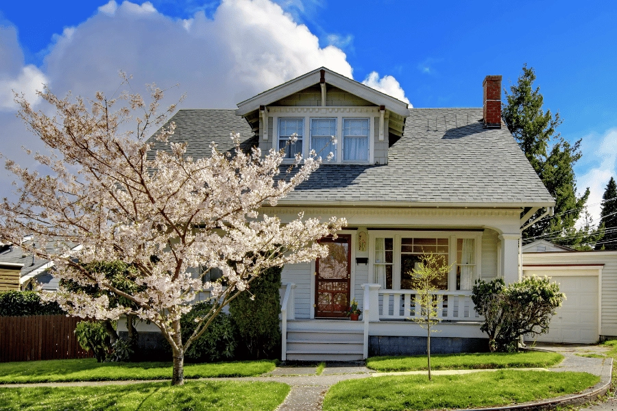 smaller mid-size home with cute front porch and red door